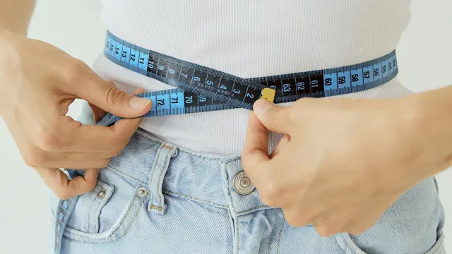 Kobieta oblicza podstawową przemianę materii używając centymetra krawieckiego